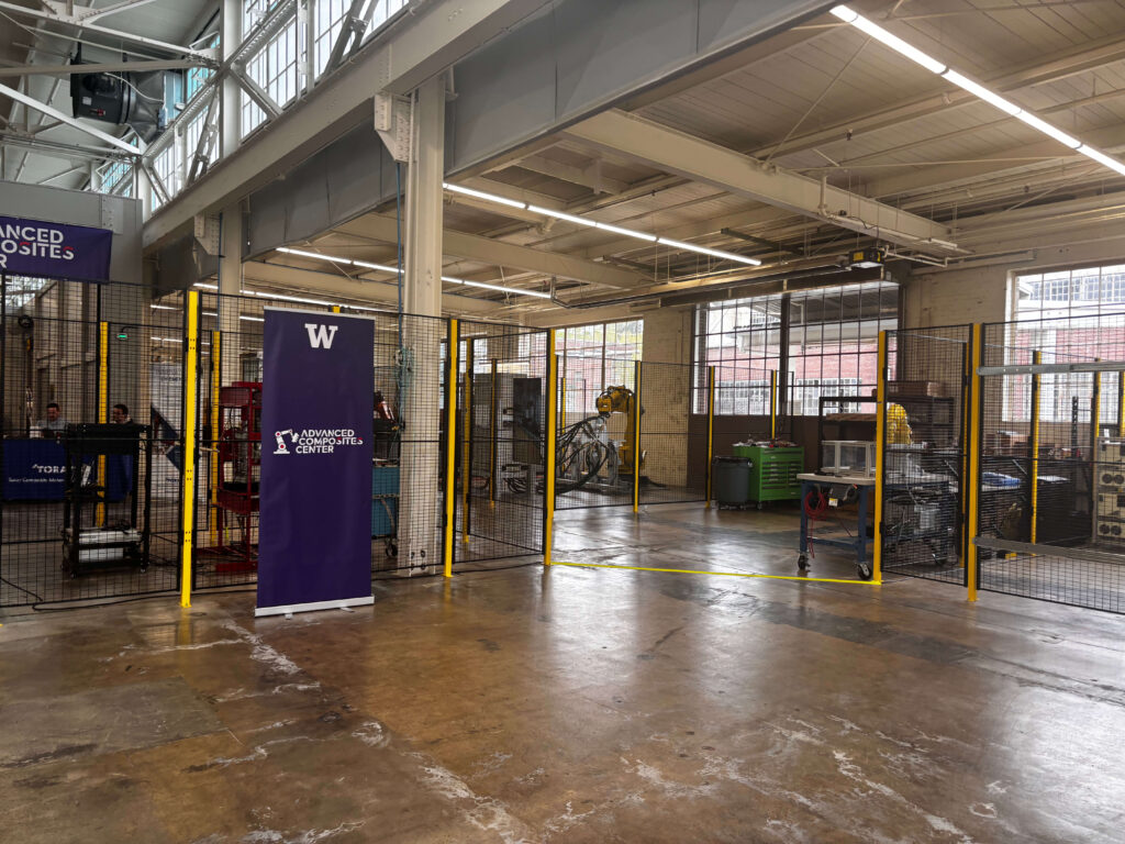 Entry way of factory space with vertical banner featuring a W logo at the top and text below that reads Advanced Composites Center.